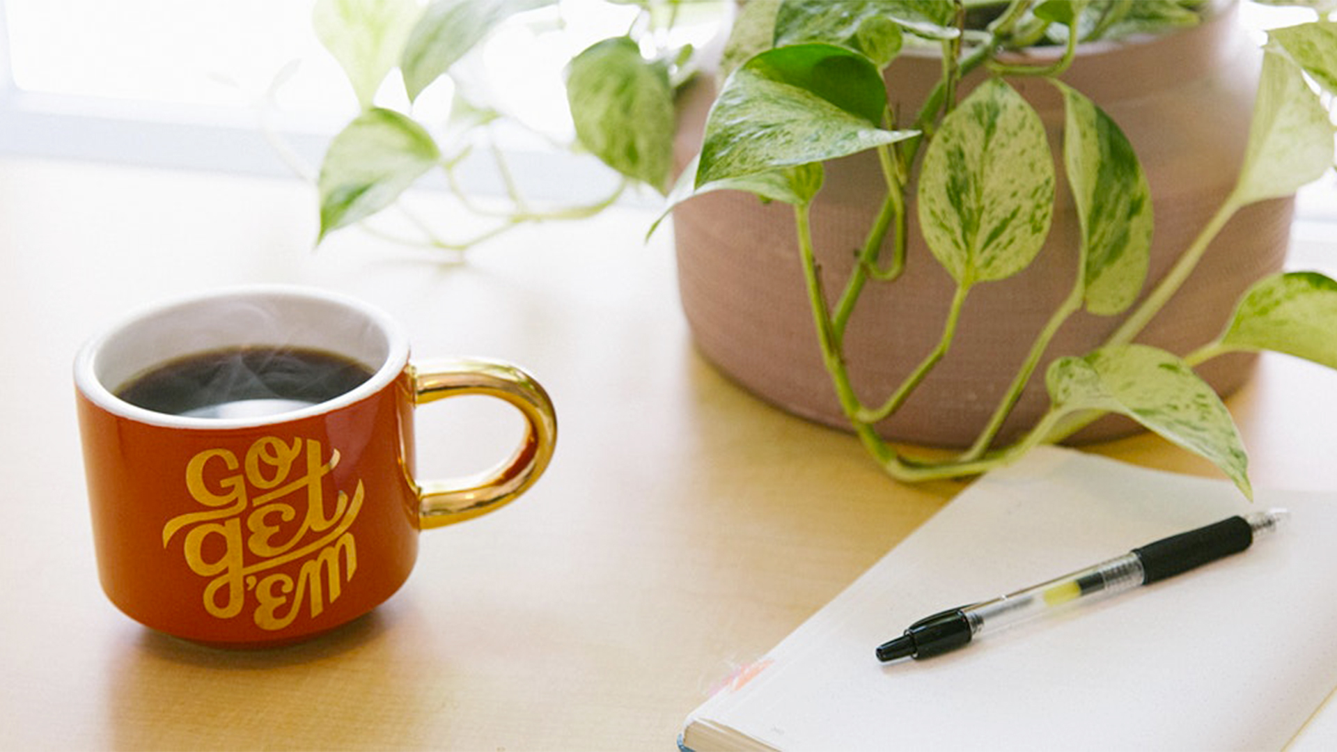 Photo of writing pad, pen, and a cup of coffee