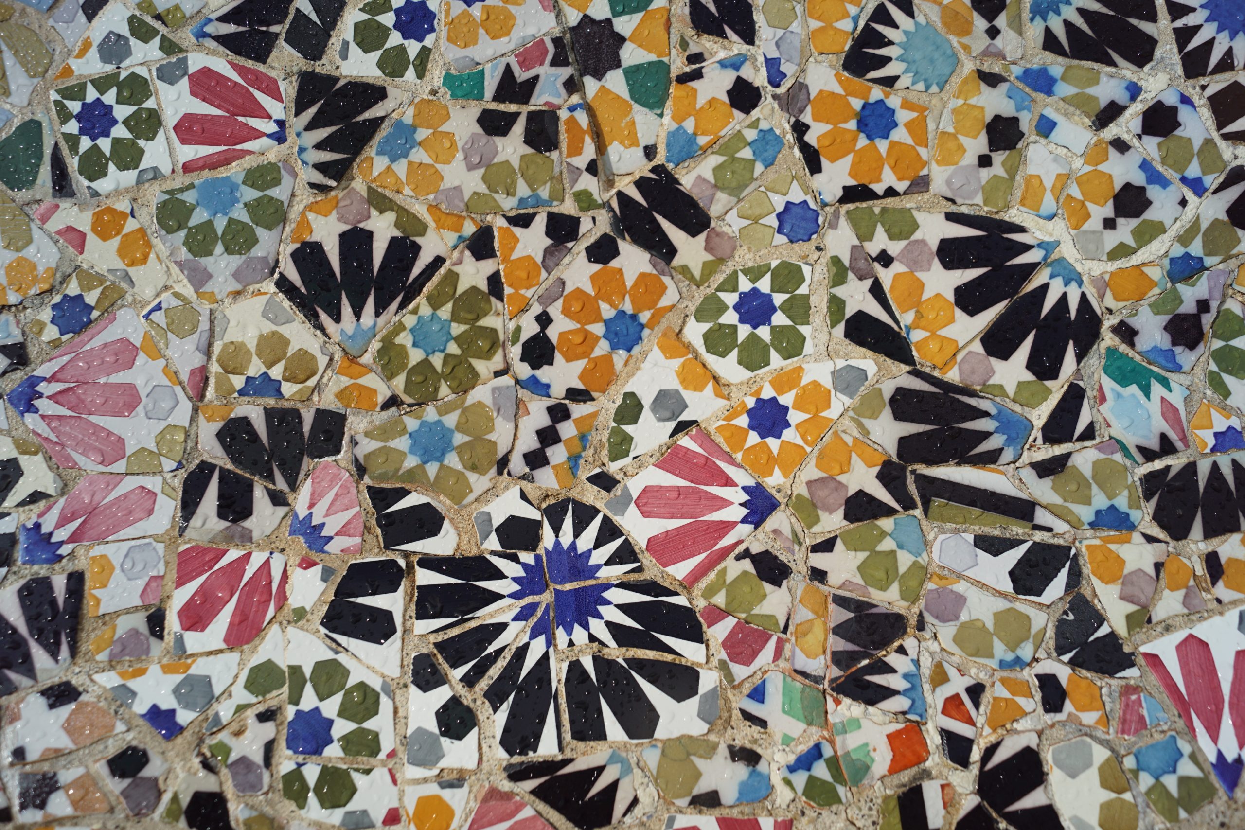 The image depicts a mosaic made of differently colored and patterned ceramic tiles