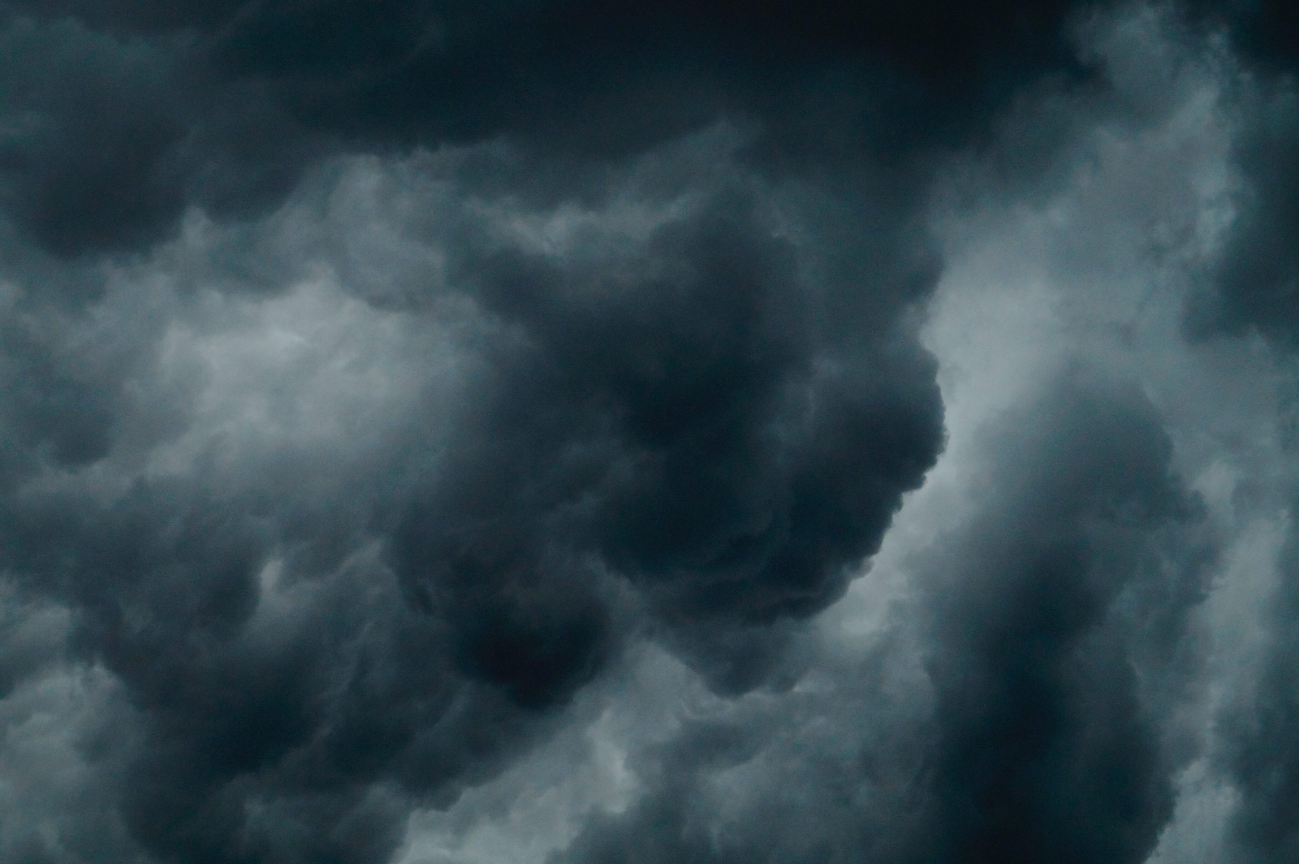 The image depicts swirling dark clouds in the sky with the suggestion of an upcoming or ongoing storm