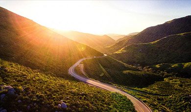 Image of a road winding away into the setting sun