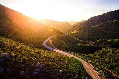 Image of a road winding away into the setting sun