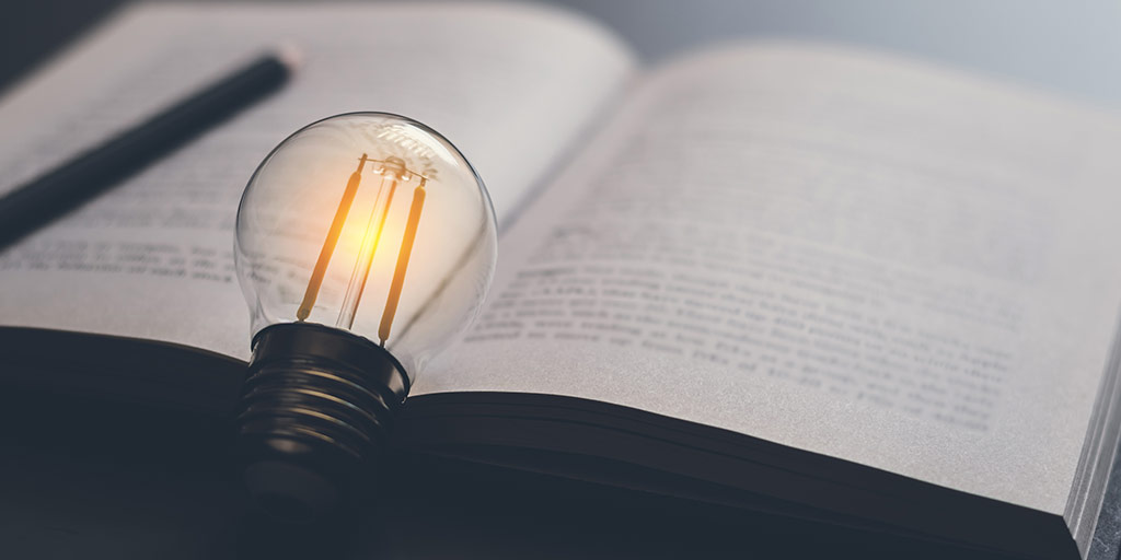 Illuminated lightbulb on an open book