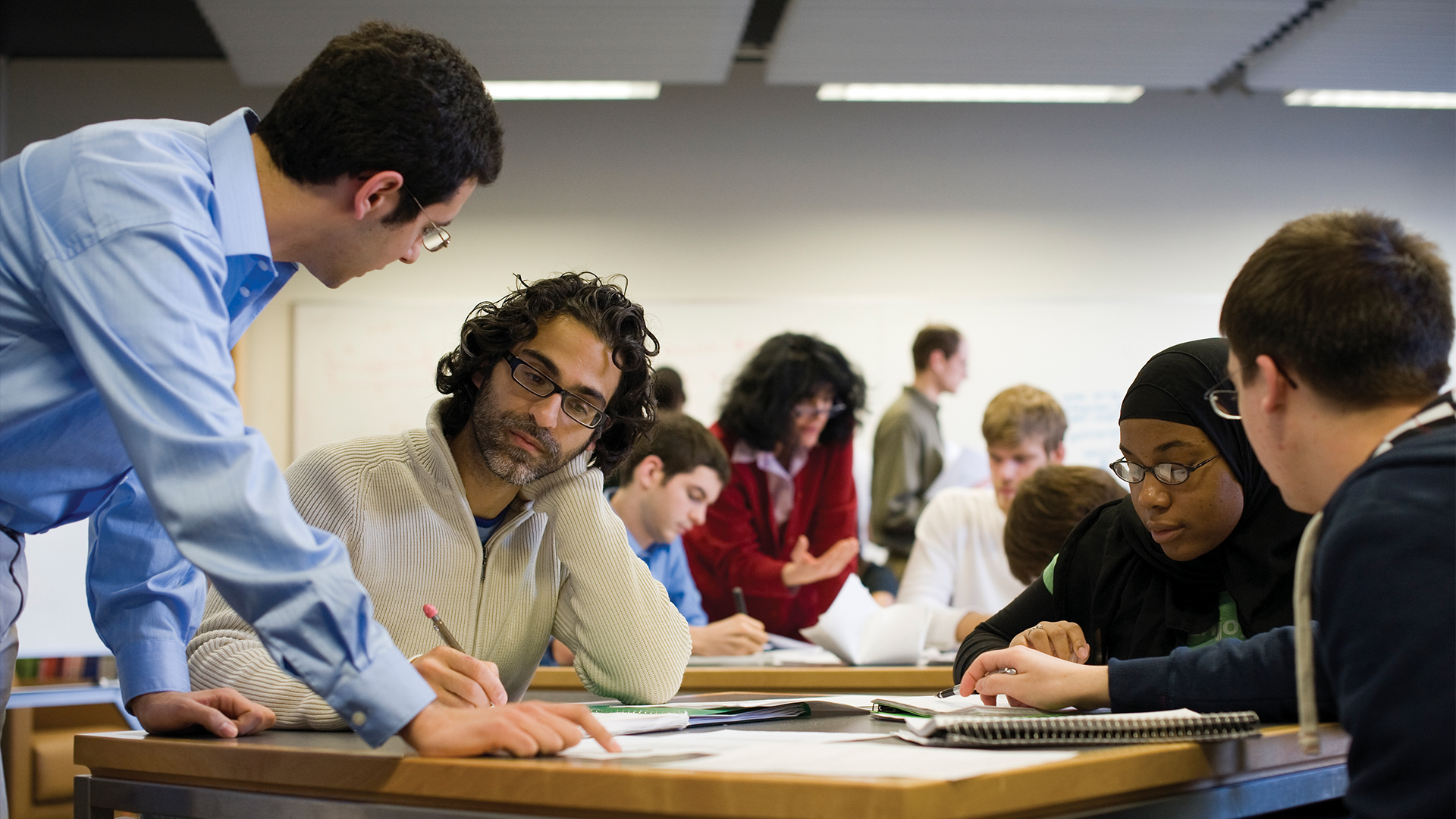 Students and instructors working together at a desk