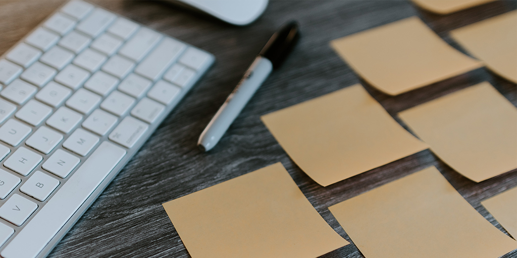 Pen, sticky notes, and sharpie on a desk